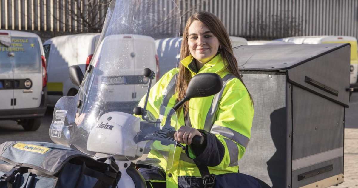 Una portalettere alla guida di uno scooter di Poste Italiane